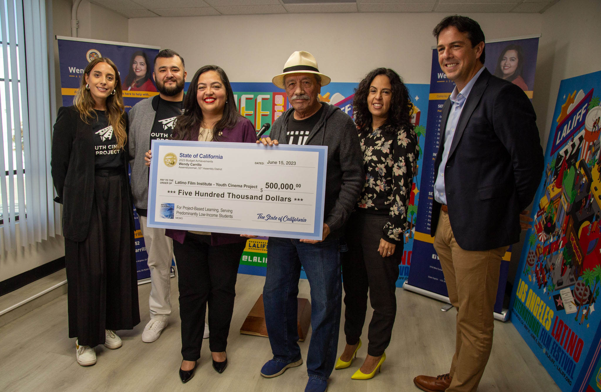 Assemblywoman Wendy Carrillo holds large symbolic check of $500,000 for the Latino Film Institute (LFI) with Actor/Producer Edward James Olmos and LFI leadership. 